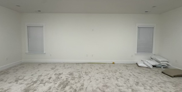 Before photo showing blank wall between two windows